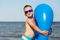 Little kid holding an inflatable mattress on the beach on hot summer day Royalty Free Stock Photo
