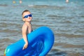 Little kid holding an inflatable mattress on the beach on hot summer day Royalty Free Stock Photo