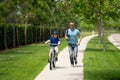 Little kid learning to ride bicycle with father in park. Father teaching son cycling. Father and son learning to ride a Royalty Free Stock Photo