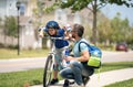 Little kid learning to ride bicycle with father in park. Father teaching son cycling. Father and son learning to ride a Royalty Free Stock Photo