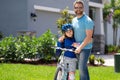 Little kid learning to ride bicycle with father on on summer holiday. Father teaching son cycling. Father and son Royalty Free Stock Photo