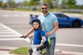 Little kid learning to ride bicycle with father on on summer holiday. Father teaching son cycling. Father and son Royalty Free Stock Photo