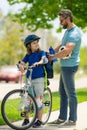 Little kid learning to ride bicycle with father on on summer holiday. Father teaching son cycling. Father and son Royalty Free Stock Photo