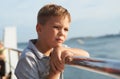 Little kid looking at the sea from the railing of a cruise Royalty Free Stock Photo