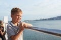 Little kid looking at the sea from the railing of a cruise Royalty Free Stock Photo