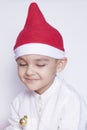A little kid making a funny annoyed face. Annoyed Christmas Boy in Santa Hat. A really serious and handsome kid Royalty Free Stock Photo