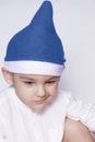 A little kid making a funny annoyed face. Annoyed Christmas Boy in Santa Hat. A really serious and handsome kid Royalty Free Stock Photo