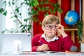 Little kid making school homework on computer. Child learning on pc. Hard working boy making exercise during quarantine Royalty Free Stock Photo