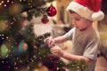 A little kid ornamenting a Christmas tree at home. Together, New Year, family, celebration Royalty Free Stock Photo