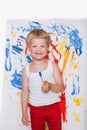 Little kid painting with paintbrush picture on easel. Education. Creativity Royalty Free Stock Photo