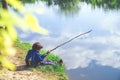 Child play fishing near lake. Royalty Free Stock Photo