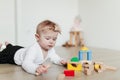 Little kid playing with colorful wooden building blocks. Blurred background Royalty Free Stock Photo