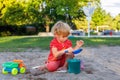 Little kid playing with sand and toys outdoors in summer. Child in park. Girl at playground Royalty Free Stock Photo