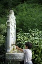 Little kid playing with water from Ottoman style classic fountain Royalty Free Stock Photo