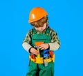 Little kid repairman with toolbelt. Tools for building. Builder boy in safety helmet and toy tools for repair Royalty Free Stock Photo