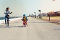 Little kid riding a balance bike with his mother on a bicycle