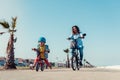 Little kid riding a balance bike with his mother on a bicycle