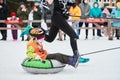 Little kid on snow tubing with sled dog