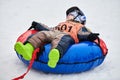 Little kid on snow tubing with sled dog Royalty Free Stock Photo