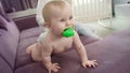 Little kid with toy in mouth crawling on sofa. Funny child learning walk Royalty Free Stock Photo