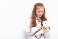 Little kid using Doctor suit and equipment to check Teddy bea Royalty Free Stock Photo