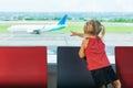Little kid wait for boarding to plane flight in airport
