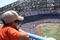 Little kid is watching baseball game on a big stadium