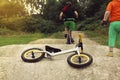 Little kid watching her red haired mom riding a bike on a pumptrack with excitement, balance bike lying on the ground Royalty Free Stock Photo