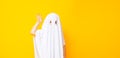 Little kid wearing cute halloween ghost costume on yellow background Royalty Free Stock Photo