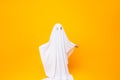 Little kid wearing cute halloween ghost costume on yellow background Royalty Free Stock Photo