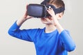 Little kid wearing virtual reality goggles watching movies or playing video games Royalty Free Stock Photo