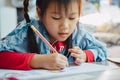 Little kids drawing cartoon with color pencil that is good activity for improve creative art and hand writing skills Royalty Free Stock Photo