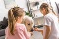 little kids feeding golden retriever dog with treats