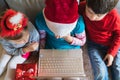 Little kids girls, boy have video call, onine virtual conference in laptop.Red Christmas santa claus,elf hat. Congratulations,