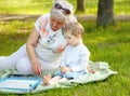 Little kids and grandmother. Young boys and grandmother in sunny park.