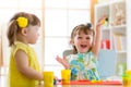 Little kids having fun together with colorful modeling clay at daycare. Creative kids molding at home. Children girls play with pl Royalty Free Stock Photo