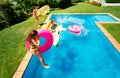 Little kids in mid air jump into pool water Royalty Free Stock Photo