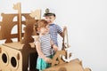 Little kids playing with cardboard ship on white background. Hap Royalty Free Stock Photo