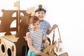 Little kids playing with cardboard ship on white background. Hap Royalty Free Stock Photo