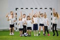 Little kids playing football indoors. Children football team. Hands up and jumping