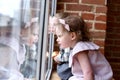 Little kids or siblings concept. Cute toddler girl and boy at window sill looking outside