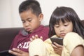 Little kids sister and brother siblings plays on gadget smart phone Royalty Free Stock Photo