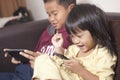 Little kids sister and brother siblings plays on gadget smart phone Royalty Free Stock Photo