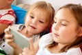 Little kids with smartphone in bed at home Royalty Free Stock Photo