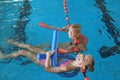 Little kids with swimming noodles in indoor