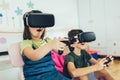 Kids in virtual reality headsets playing video game at home Royalty Free Stock Photo