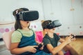 Kids in virtual reality headsets playing video game at home Royalty Free Stock Photo