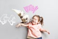 Little laughing cute girl fighting with toy cat. Comic scene Royalty Free Stock Photo