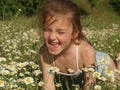 Little girl among the chamomile field and green grass Royalty Free Stock Photo