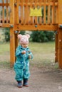 Little laughing girl blowing soap bubbles while standing on the playground